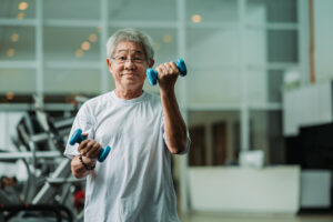 mature Asian man exercising with free weights