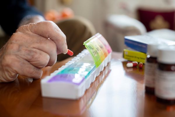 Someone sorting medications into a pill organizer
