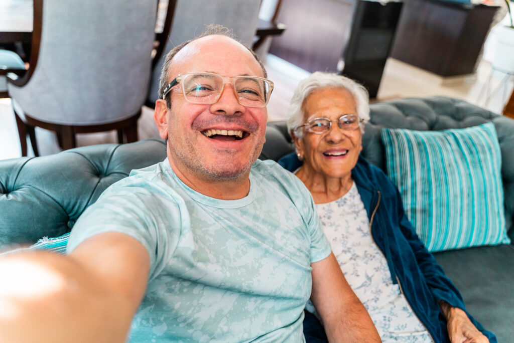 Mature man talking a selfie with mother at home - Camera point of view
